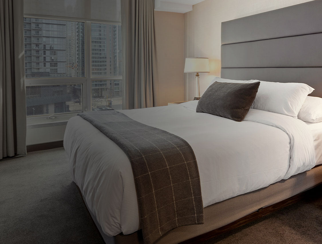 Modern hotel bedroom with a cityscape view.